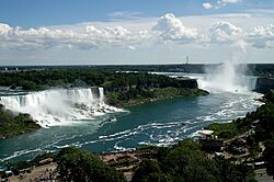 High view of Niagara Falls as viewed from the Canadian side of the river. The image includes American Falls, Bridal Veil Falls, Bridal Veil Falls, and Horseshoe Falls.