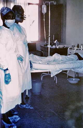 1976 photograph of two nurses in a ward, standing beside Ebola case #3 in a human patient, who died a few days later