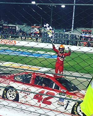 Larson thrusts the checkered flag in the air after winning the 2017 Federate Auto Parts 400