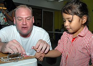 US Navy 061028-N-9662L-018 Petty Officer 1st Class Daniel Jones, a Sailor assigned to Naval Computer Telecommunications Station (NCTS) Guam, fingerprints Alexis Kosak during the 11th annual Project KidCare event held at Agana S