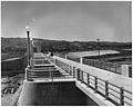 Westerly view along the top of the spillway showing the completed service bridge and handrails. The outlet control... - NARA - 295322