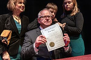 Governor Tim Walz holds up the signed oath in St. Paul, Minnesota