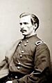 Profile of a white man with mustache wearing a double-breasted military jacket with one star on a patch on the shoulder.