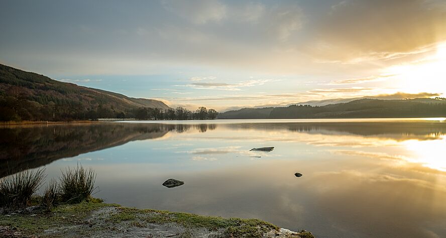 Sunrise over Loch Ard showing its crystal clear water