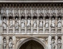 Statues of ten people in niches over a door