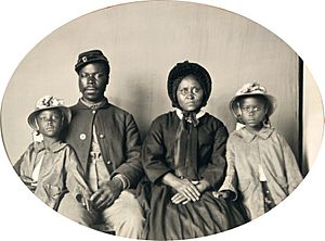 Unidentified African American soldier in Union uniform with wife and two daughters - no frame.jpg