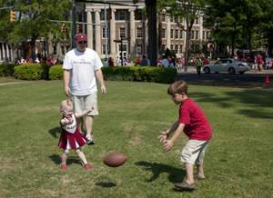 Timothy L. Pesto and Kaitlyn E. Pesto play football as their father watches, Tuscaloosa, Alabama LCCN2010638252