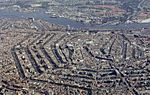 An aerial view of a cramped city, clearly spaced by hexagonal bodies of water.