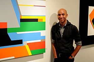 Bryce-hudson-standing-next-to-one-of-his-large-geometric-paintings.jpg