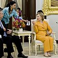 Huma Abedin handing Hillary Clinton notes and a pen