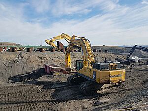 Large bulldozers remove buried pieces of pipe filled with contaminated waste