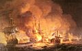 A confused naval battle. Two battered ships drift in the foreground while smoke and flames boil from a third. In the background smoke rises from a confused melee of battling ships.
