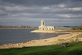 A lake with a rocky foreshore, and a small peninsula with a church built on it