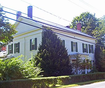A white house with black shutters and four chimneys