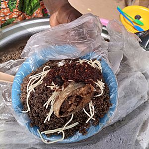 A meal of Wasawasa, black jollof, made from yam peals