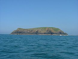 green-topped, treeless island in blue sea