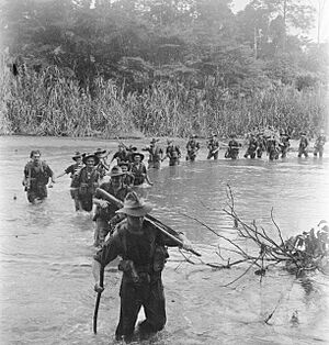 37-52 Battalion soldiers crossing a river in New Britain