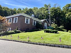 Flower Hill Village Hall in 2020, with flags on the lawn to celebrate Labor Day.