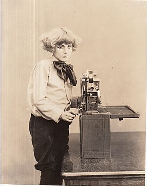 Publicity shot, girl with Edison home projecting kinetoscope. (ed47e702-68bc-44aa-a2d8-810908260916)