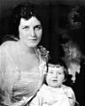Waist high portrait of woman in her twenties with a child in front of her