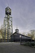 Houten zaalkerk met op de voorgrond een vrijstaande stalen klokkentoren - Koedijk - 20396714 - RCE