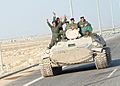 Iraqi military men riding on tank