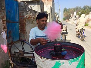 Man makes cotton candy in cotton candy machine