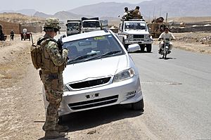U.S. Army 1st Lt. Patrick Gurski, foreground, with a security force assistance team (SFAT) with the 56th Infantry Brigade Combat Team, Texas Army National Guard, watches Afghans pass during a logistics 130604-A-FS372-018