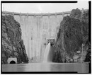 DAM AFTERBAY, WITH OWYEE RIVER IN FOREGROUND, SHOWING OUTLET TUNNEL PORTAL (LEFT) AND POWERHOUSE AND ENTRANCE PORTAL TO DAM INTERIOR (RIGHT). NOTE RELEASE OF WATER FROM NEEDLE HAER ORE,23-NYS.V,1-6.tif