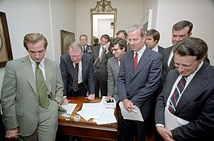 President Ronald Reagan, Ken Duberstein, George H. W. Bush, Ed Meese, Craig Fuller, Richard Darman, James Baker, Caspar Weinberger, and William Clark watching the Tax Bill vote with staff