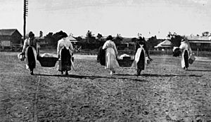Women taking baskets of food to the troop train passing through Helidon, World War I (8862018919)