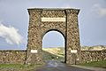 A large arch made of irregular-shaped natural stone over a road