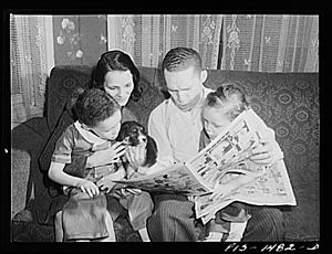 Chicago, Illinois. On Sunday afternoon at home, "Red" Saunders and his wife read the comics to their children and puppy whose name is "Blitz"