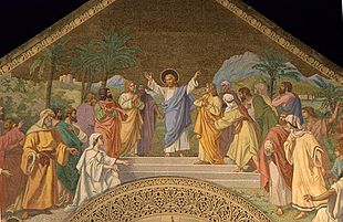 Jesus, with His arms stretched out, welcomes people who are coming towards him from both sides. A Middle eastern landscape is behind the group.