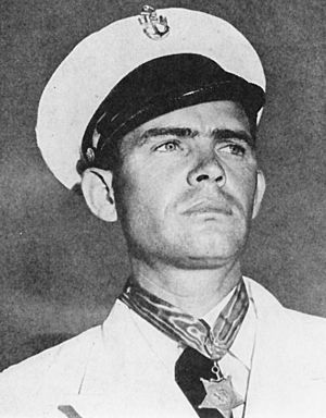 Black and white photo of male individual in chief petty officer dress whites wearing the Navy Medal of Honor