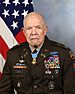 Head and shoulders of an older black man, wearing a dark military jacket, with a medal hanging from a ribbon around his neck.