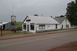 Old building with welcome sign and community bulletin board in Recluse, Wyoming.jpg