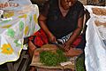 Vendeuse d'Okok en train de découper les feuilles d'okok Eru