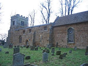 Part of a stone church seen from an angle.  At the far end is a battlemented tower, in front of which is a nave with a flat parapet, and part of a chancel with a tiled roof