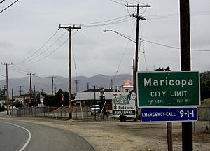Northern city limit of Maricopa; the fire in the center is a gas flare from an active oil well
