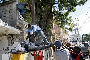 Haitians pull out a body from the rubbles of a school (12 january 2010)