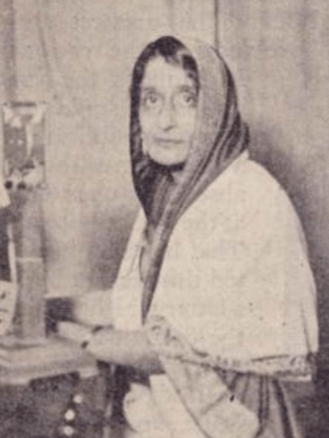 A South Asian woman of middle age, her head covered with a shawl