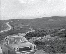 Photograph of Wade's Causeway, taken in approximately 1978, showing a car of the period parked at the start of the Skvick section of the structure