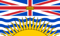 Flag with horizontally stretched Union Flag as top half. The lower half is a large yellow sun over blue and white waves.