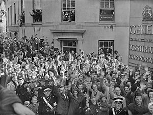 Crowds of people gathered ouside the General Assurance Corporation building in St Peter Port, Guernsey to welcome the British Task Force sent to liberate the island from German occupation, 10 May 1945. D24590