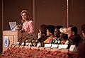 Clinton speaking at a podium with several onlookers. She is delivering her "human rights are women's rights and women's rights are human rights" speech in Beijing during September 1995.