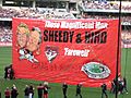 A red banner featuring drawings of former Essendon player James Hird and former coach Kevin Sheedy