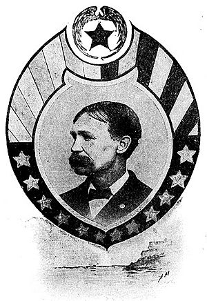 Profile of a white man with slicked down hair and a bushy mustache wearing a dark suit and bow tie. The portrait is surrounded by a circular frame with stars and stripes.