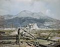 The ruins of Cassino, May 1944- a wrecked Sherman tank and Bailey bridge in the foreground, with Monastery Ridge and Castle Hill in the background. TR1799