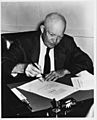 Photograph of President Dwight D. Eisenhower Signing the Civil Rights Act of 1957 (H.R. 6127) in His Office at the Naval Base in Newport, Rhode Island - NARA - 7865612